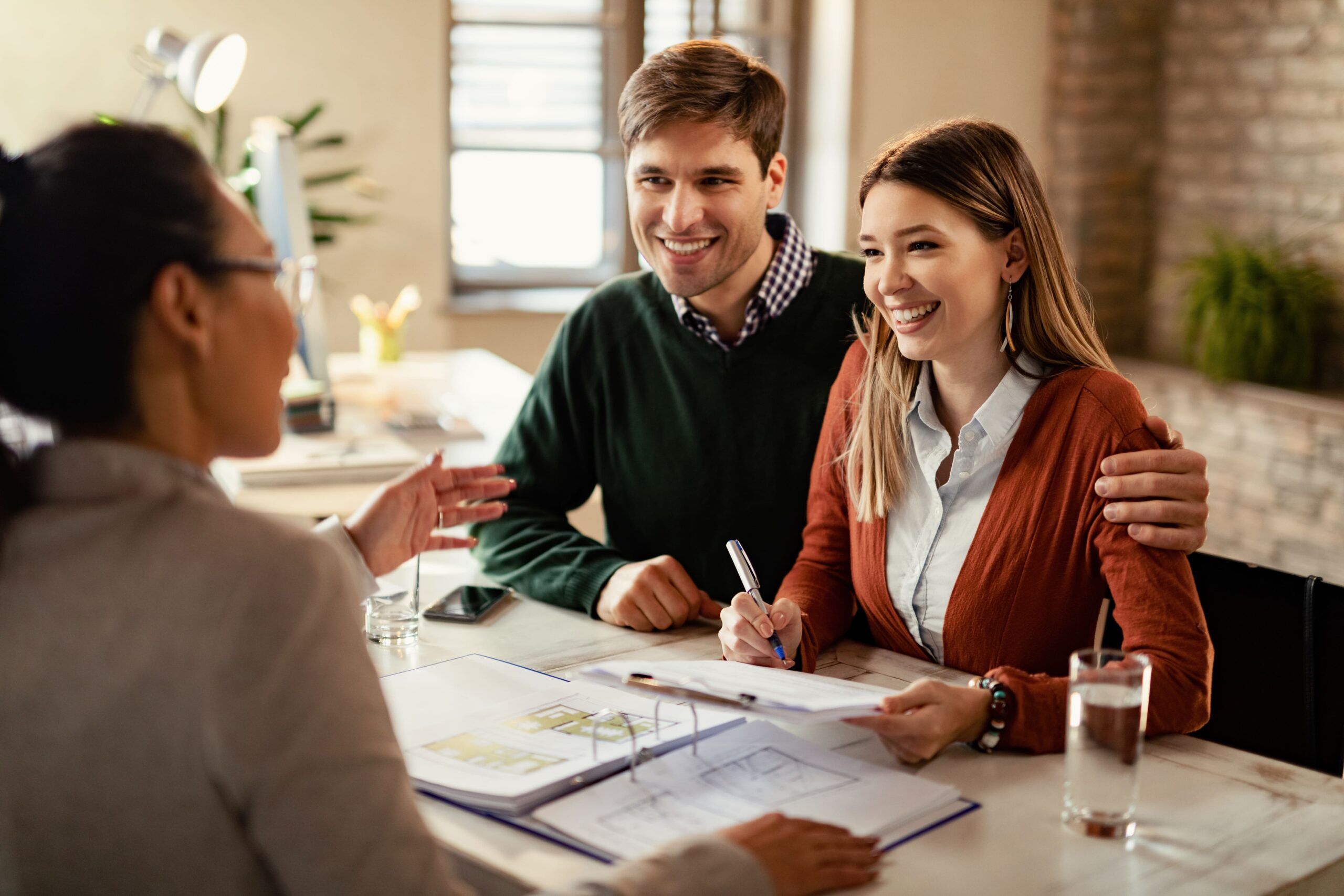 Casal feliz fechando o financiamento bancário